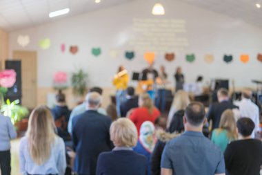 Çocuklar sahnede ailelerin önünde gösteri yapıyor. Ebeveynler çocukların performansını izliyor. Çocuklar bayramı.