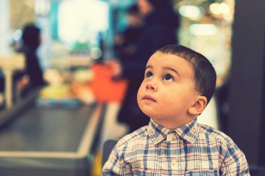 Süpermarkette para içinde yüzen küçük çocuk. ses tonlu.