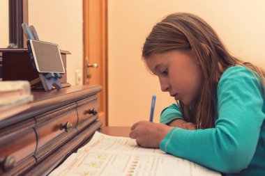Evde eğitim. Liseli kız evde online dersi sırasında ödev matematiği okuyor, karantina sırasında sosyal uzaklık, kendini soyutlama, online eğitim konsepti, ev okulu.