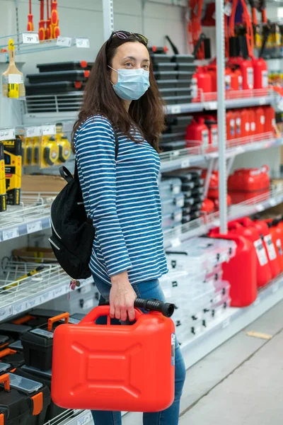 Woman in protective mask in a store with a canister. pandemic concept. Pandemic Shopping. vertical photo.