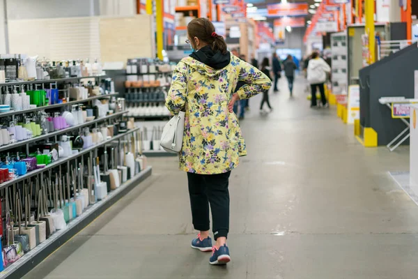 Woman in protective mask at the mall. Alarmed female wears medical mask against coronavirus while grocery shopping in supermarket, safety and pandemic concept - young woman wearing protective mask