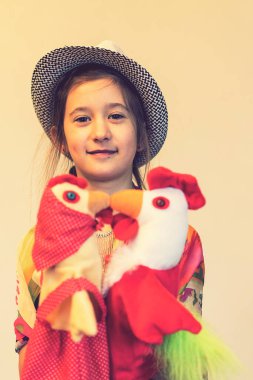 8 yaşında iki tavuk ve horoz oyuncağı olan bir kız. ses tonlu.