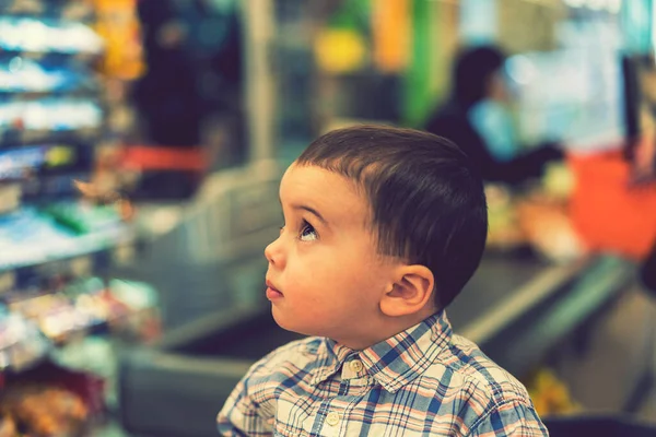 Rapazinho Num Fundo Dinheiro Num Supermercado Tonificado — Fotografia de Stock