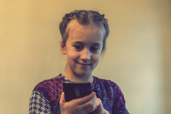 Akıllı Telefonlu Gülümseyen Küçük Bir Kız Ses Tonlu — Stok fotoğraf