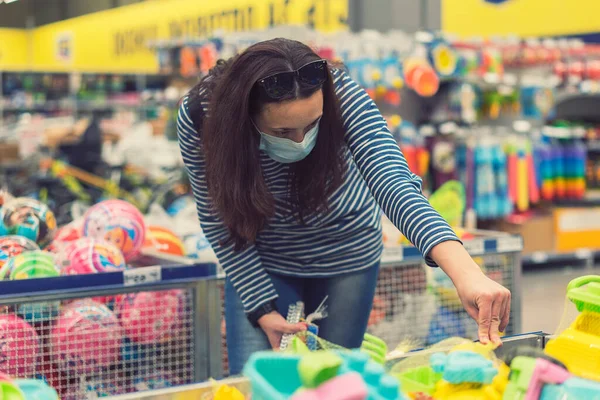 Женщина Защитной Маске Супермаркете Выбирает Детские Игрушки Тонированные — стоковое фото