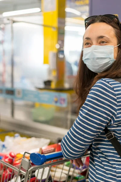 Asian young woman wearing a hygiene protective mask over her face while walking at the crowded shopping mall. Covid19 influenza in crowded place. woman wearing a mask in the supermarket.