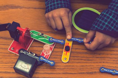 Elektrikli bir inşaatçıyı oynayan çocuk. Çocuk entellektüel oyuncaklar tarafından oynanır. Mavi gömlekli bir çocuk elektronik ustası. Çocukların erken gelişimi kavramı. ses tonlu.