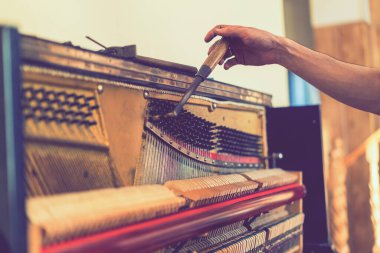 Piyano akort işlemi. Büyük piyanoda çalışan el ve akort aletlerinin yakın çekimi. Akort sırasında Upright Piano 'nun detaylı görüntüsü. ses tonlu.
