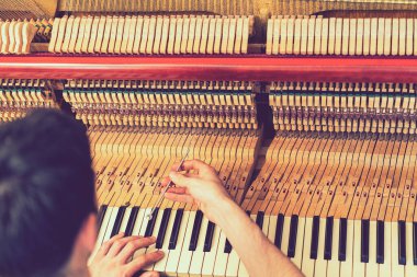 Piyano akort işlemi. Büyük piyanoda çalışan el ve akort aletlerinin yakın çekimi. Akort sırasında Upright Piano 'nun detaylı görüntüsü. ses tonlu.