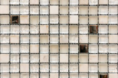 Mutfak, banyo veya havuzu dekore etmek için beyaz ve kahverengi kabartmalı karoları olan seramik mozaik fayanslar. Kare şeklinde kahverengi mermer mozaiği.