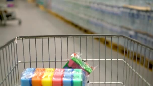 Caminhe pelas fileiras do supermercado. Vista do carrinho de compras. Comércio, vendas. Os clientes vão em busca de bens. Os compradores caminham pelo território — Vídeo de Stock