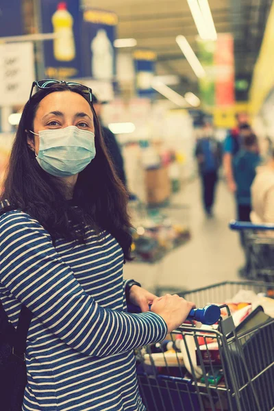 Asian young woman wearing a hygiene protective mask over her face while walking at the crowded shopping mall. Covid19 influenza in crowded place. woman wearing a mask in the supermarket. toned.