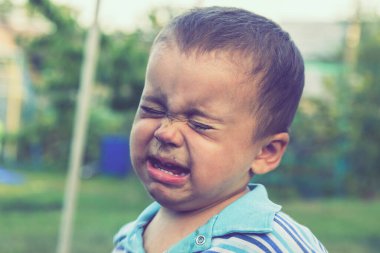 Ağlayan bir erkek bebeğin portresi. Ağlayan bebek. Açık hava..