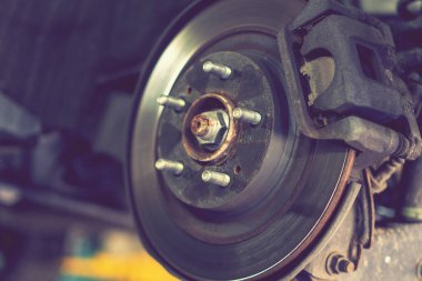 Araba servisindeki bir tekerleğin merkezi. Tekerleksiz, askıya alınmış bir araba. Servis odasındaki arabanın süspansiyonu. Araba asansörle kaldırılarak bakım süspansiyonu ve temizlik parçaları için kaldırılıyor. Kapatın. ses tonlu.