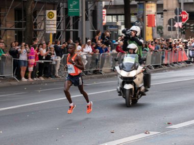 Berlin, Almanya - 16 Eylül 2018: Kameramanların Berlin Maratonu 2018 Berlin, Almanya'da çalışan Kenyalı uzun mesafe koşucusu Amos Kipruto filme bir motosiklet üzerinde