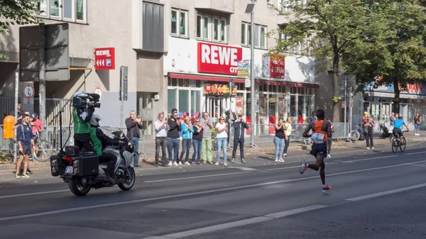 BERLINO, GERMANIA - 16 SETTEMBRE 2018: Videografo su una motocicletta Le riprese del corridore keniano Amos Kipruto alla maratona di Berlino 2018 A Berlino, Germania — Foto Stock