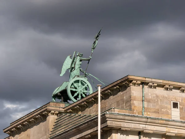 Kwadryga Bramy Brandenburskiej przeciwko ciemnym zachmurzone niebo w Berlin, Niemcy — Zdjęcie stockowe