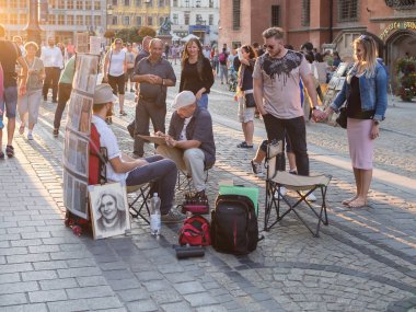 Bir turist Rynek Market Wroclaw bir portresini sokak ressam
