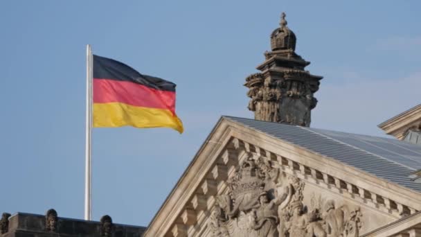 Tysk flagga på Riksdagshuset i Berlin som fladdrar i vinden, panorering skott — Stockvideo