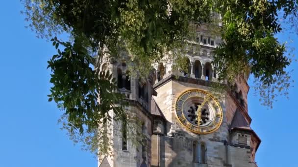 Reloj del Kaiser Wilhelm Memorial Church Detrás de un árbol en Berlín, Alemania — Vídeo de stock