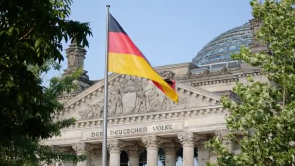 風になびく、ドイツのベルリンにある国会議事堂の前にドイツの旗 — ストック動画