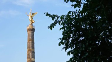 Zafer Anıtı, Berlin, Almanya mavi bulutlu gökyüzü karşı bir ağacın arkasında