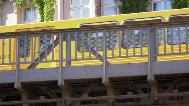 Gele BvG U-Bahn metro trein voor een huis met klimplanten — Stockvideo