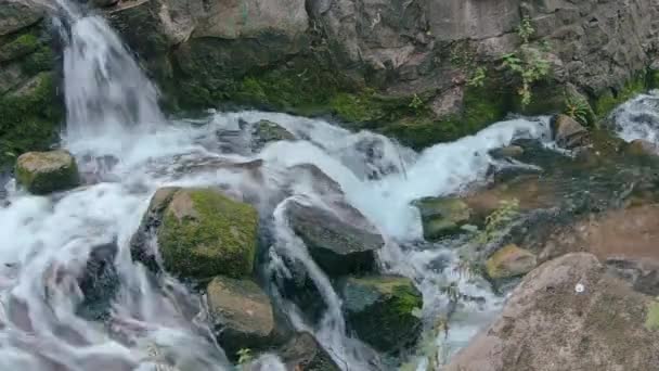 Nahaufnahme eines kleinen Wasserfalls mit bemoosten Felsen — Stockvideo