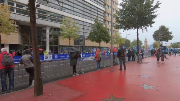 Lopers en toeschouwers in de regen op de marathon van Berlijn 2019 in de buurt van Potsdamer Platz — Stockvideo