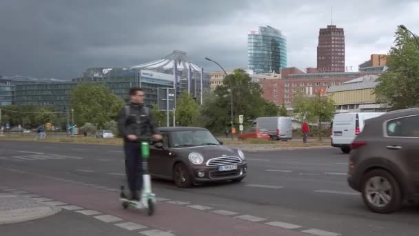 Электронные скутеры на культурном форуме с куполом и небоскребами Потсдамской площади в Берлине — стоковое видео