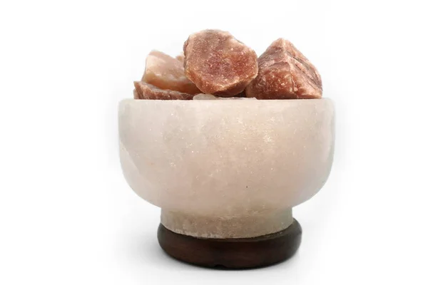 Bej tuzlu vazo-gece ışığı taşlardan yapılmış doğal kaya tuzu yakın çekim beyaz bir arka plan üzerinde izole. Gevşeme ve stres giderme için lamba çeşitli hastalıkları tedavi eder.