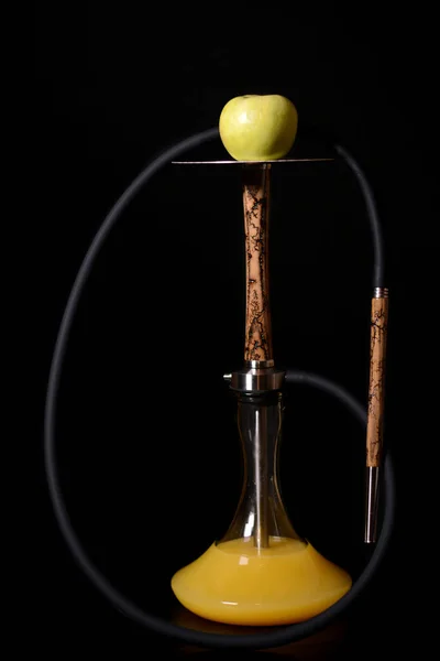 Siyah bir arka plan üzerinde siyah hortum ile metal plaka üzerinde elma ile şık bej ahşap nargile. Sap ı ve ağızlıküzerinde şimşek siluetleri. Su bir kavanozda sarı suyu.
