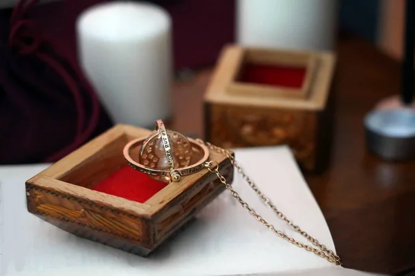 Bulanık bir arka plan üzerinde kitap üzerinde ahşap kutu içinde bir zincir ile Büyülü altın yuvarlak maskot. Gizli, ezoterik, falcılık ve wicca konsepti. Mistik ve vintage arka plan.