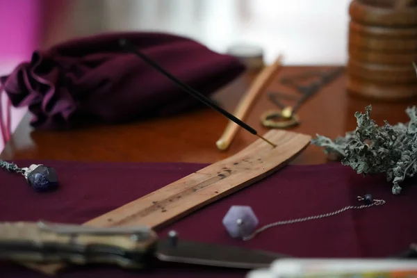 La composición de los objetos esotéricos en la mesa de madera se utiliza para la curación, meditación, purificación. Palillo de aroma, vela, piedras de amatista, cuchillo ritual, sobre fondo oscuro. Concepto oculto, esotérico y Wicca . — Foto de Stock