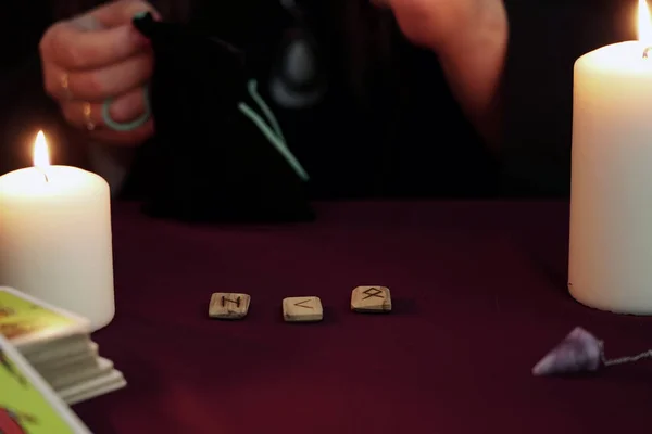 Cadı, siyah mantolu bir falcı. Eski yazıtlarla büyülü bir ayin yapıyor. Tarot kartları, ametist taşları, karanlık ve gizemli arka planda beyaz mumlar. Okült, esrarengiz, kehanet ve cadı kavramı.