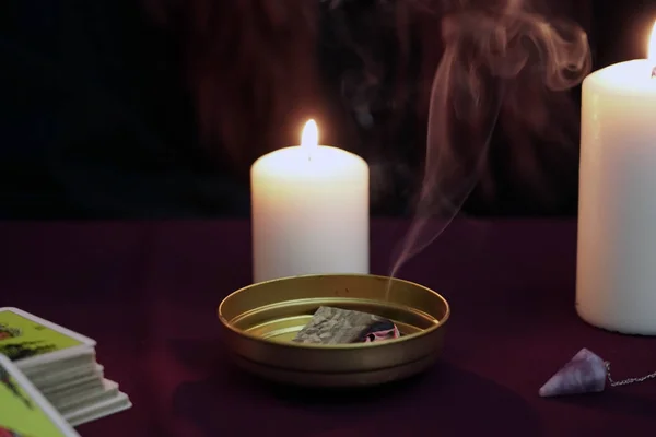 Ritual mágico con papel humeante con humo en un tazón dorado. Tarjetas del tarot, piedra amatista, velas blancas sobre fondo místico oscuro. Concepto oculto, esotérico, adivinación y wicca. Tono frío . — Foto de Stock