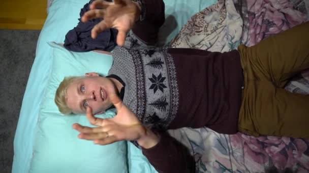 Młody Biały Blondyn Pulowerze Zegarkiem Leży Łóżku Turkusowej Poduszce Pokoju — Wideo stockowe
