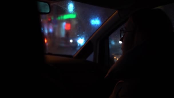 Girl Glasses Sits Passenger Seat Dark Car Looks Windshield Multicolored — Stock Video