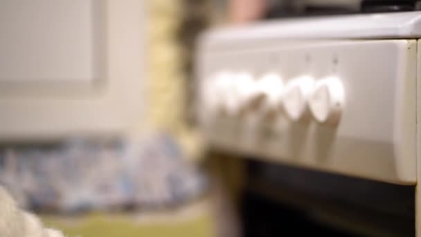 一只穿着白色羊毛的雌性手拿着一个玫瑰金修甲 手里拿着一个白色的把手 在黄墙的背景上关上了烤箱的门 房子有裂缝 — 图库视频影像