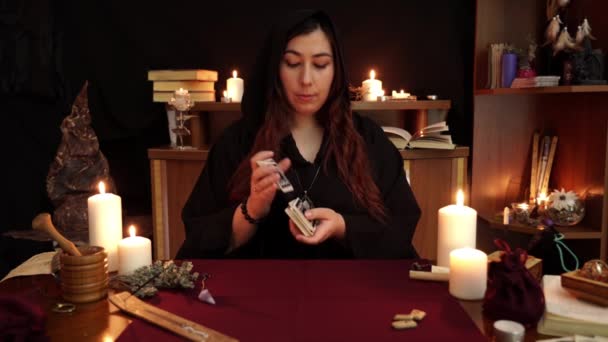 魔女は魔法のブレスレットを持つ占い師は タロットカードのデッキを保持しています タロットカード 古代ルーンと白いろうそく オカルト 占いとウィッカの概念 神秘的でヴィンテージの背景 — ストック動画