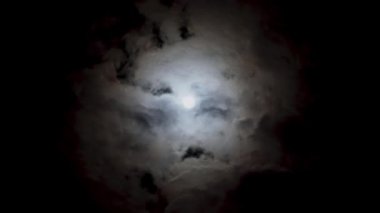 Bulutlu bir günde gece mavisi gökyüzünde romantik dolunay manzarası. Hacim kümülüs bulutları arasında parlak beyaz ay. Bulutlar gökyüzünde hızlı koşar. Ezoterik zaman.
