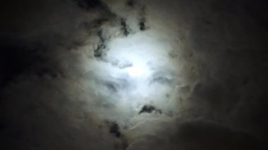 Bulutlu bir günde gece mavisi gökyüzünde dramatik ayın görünümü. Hacim kümülüs bulutları arasında parlak beyaz ay. Kehanet zamanı.