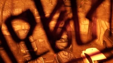 Taşıma üzerinde siyah Marker dışarı ile yazıtlar ile boyalı çamurlu turuncu pencere aracılığıyla bir endüstriyel fabrika içinden görüntüleyin. Arabalar orman içinde su birikintiler ve ağaçlar arasında stand.