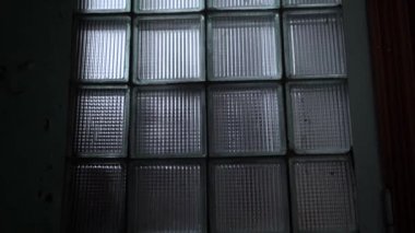 Arkalarında yansıma aydınlatma ile karanlık bir odada Cam tuğla desen pencere yakın çekim. Tasarım arka planı için soyut blok duvarlar. Iç cam yüzeyi. SSCB'den güvenlik konsepti.