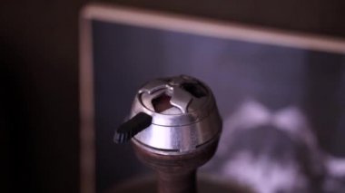 Metal bir kapta sıcak kırmızı kömürler. Erkek elleri nargile kaloud bir kil kase üzerinde plastik bir sapı ile kapatın ve bulanık karanlık bir arka plan üzerinde duman bulut darbeler.