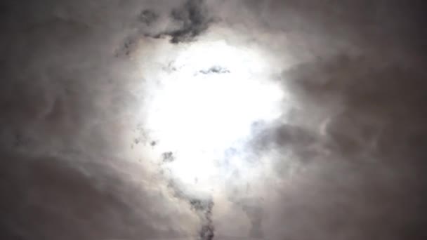 曇りの日に夜空に劇的な大きな月の眺め 積雲の間に明るい白い月 月からの輝き 雲は空を横切ってゆっくりと走る 分割時間 — ストック動画
