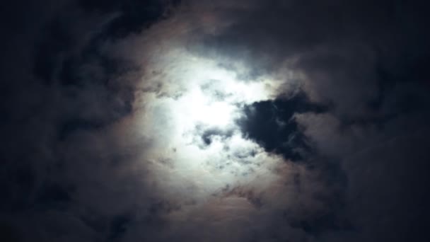 曇りの日の夜の青空にドラマチックな月 ふわふわの積雲の間の明るい白い月 雲がゆっくりと空を横切って走る オオカミ時間 — ストック動画
