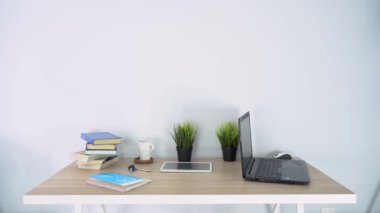 Ofisteki bir toplantıda iki genç kendinden emin iş adamı el sıkışıyor, başarı, anlaşma, selamlama ve ortaklık konsepti masa, dizüstü bilgisayar ve kitaplarla birlikte çalışma alanının arka planında kapanıyor.