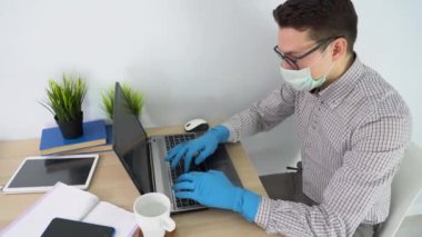 Beyaz, beyaz, beyaz, yakışıklı esmer adam siyah gözlük takıyor, tıbbi koruyucu yüz maskesi takıyor, dizüstü bilgisayar kullanıyor, mesajları cevaplıyor, yazı yazıyor. Salgın döneminde çalışan bir iş adamı. Konsepti kilitle