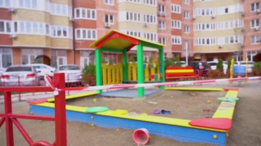 Kırmızı beyaz uyarı kurdelesi girişe doğru gerilmiş. Rusya 'da siyahi çocukların oyun parkının kapalı, kapalı bir alanı. Karantina, tecrit. Giriş yasak. Yasak bölge. Sınırlı erişim.